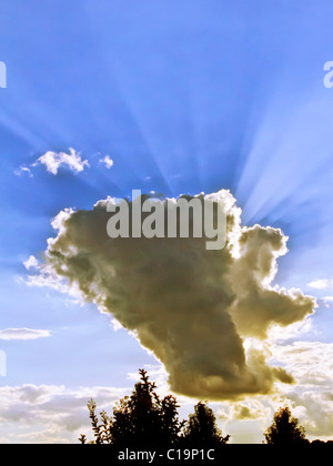 Spectulay Cumulonimbus cloud formation with sun behind projecting light rays. Stock Photo
