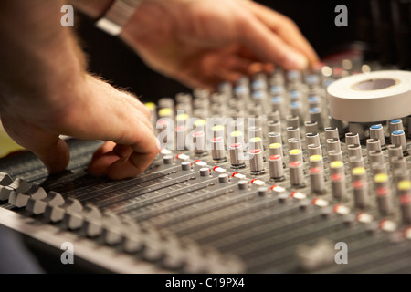sound engineer adjusting audio mixing desk in a theatre concert hall Stock Photo