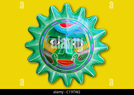 Mexican indian sun handcraft ceramic isolated in yellow background Stock Photo