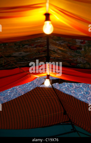 View of a street fair where the ceiling is made up of stitched pieces of cloth of various colors. Stock Photo