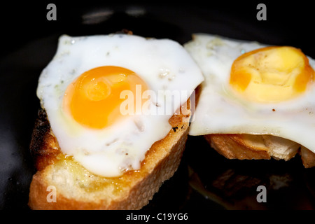 fried quails eggs on buttered toasted bread Stock Photo