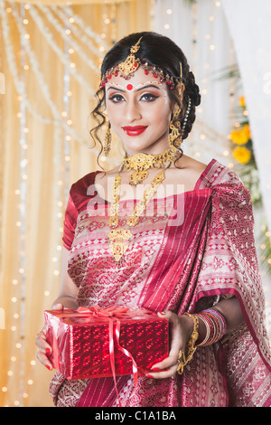 Portrait of a bride in traditional Bengali dress holding a gift Stock Photo