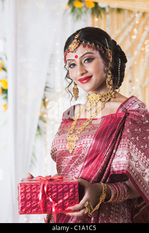 Portrait of a bride in traditional Bengali dress holding a gift Stock Photo