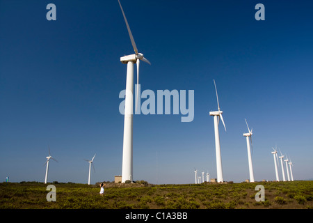 View of a young girl watching a field of windmills. Stock Photo