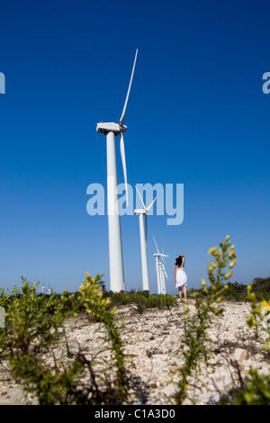 View of a young girl watching a windmill. Stock Photo