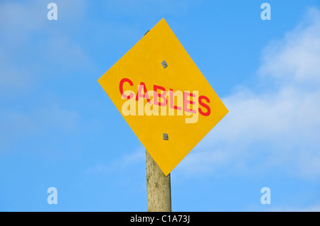 Close up of electric electricity power cable cables warning sign Wales UK United Kingdom GB Great Britain Stock Photo