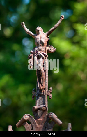 Rusty old Jesus statue without cross. Green forest in the background. Stock Photo