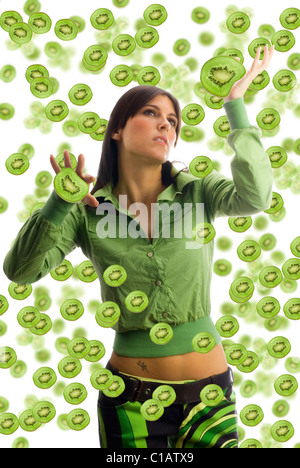 pretty girl with colored dress and pieces of fruit all around her Stock Photo