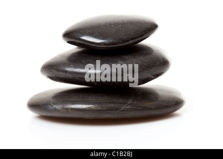 pile of three black pebbles over white background Stock Photo