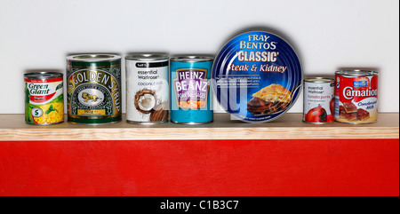 A row of tinned goods sit on a shelf Stock Photo