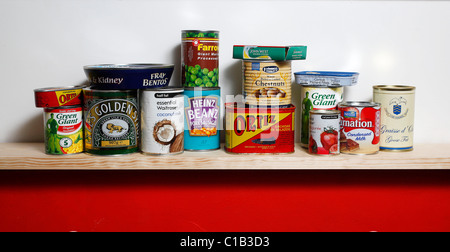 A row of tinned goods sit on a shelf Stock Photo