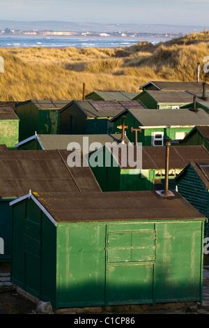 Several Tarpaulin roofed Fisherman's huts with chimneys; A hundred “South Gare Fishermen’s Association” cabins. Multiple sheds with doors & windows Stock Photo