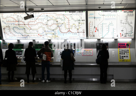 Customers buying train tickets at automated ticket machines, Yokohama Station JP Stock Photo