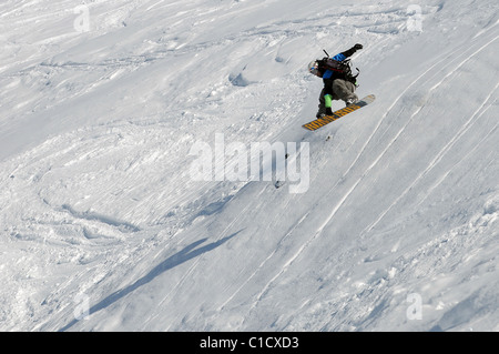 A snowboarder jumps in powder snow in the French ski resort of Courchevel. Stock Photo