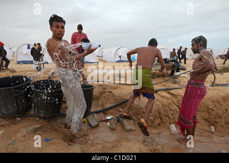 Bangladeshi washing themselves in the Shousha refugee camp, Ben Gardane, Tunisia Stock Photo