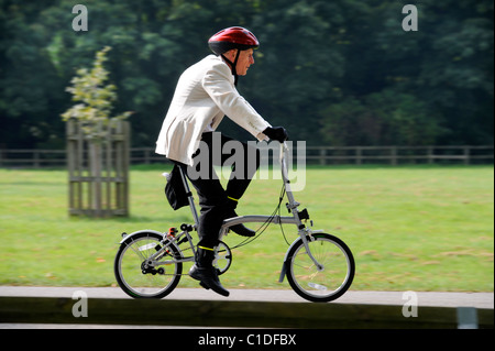 An older competitor in the Brompton World Championships commuter bike racing in the grounds of Blenheim Palace, Oxfordshire Sep Stock Photo