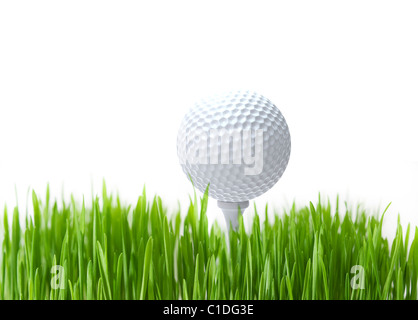 Golf ball on tee and green grass on white background Stock Photo