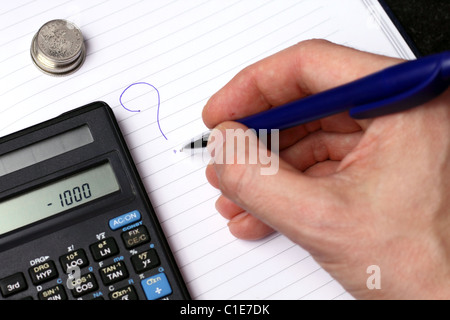 Coins, calculator, hand writing on white striped paper with blue pen Stock Photo