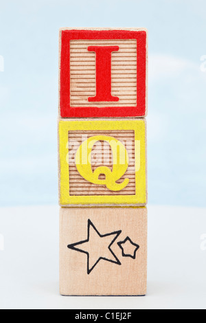 Stack of 3 alphabet letter blocks with letters spelling IQ star against a blue sky background Stock Photo