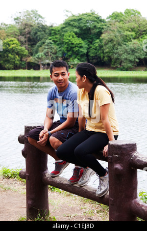 An adult male and an adult female resting beside the lake. Stock Photo