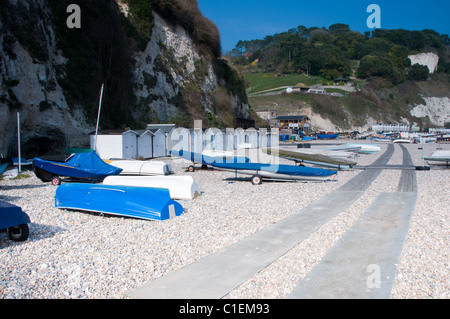 Beach huts and sailing boats on the beach at Beer in Devon, England, UK Stock Photo