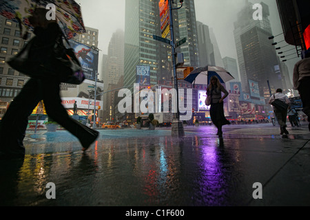 People with umbrellas on Time Square, New York,  in the rain Stock Photo
