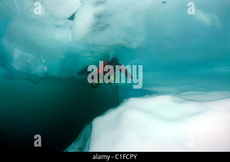 Scuba diver with sidemount under ice, in lake Baikal, Siberia, Russia, island Olkhon Stock Photo