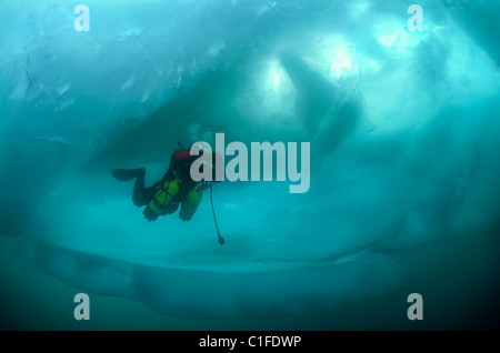 Scuba diver with sidemount under ice, in lake Baikal, Siberia, Russia, island Olkhon Stock Photo