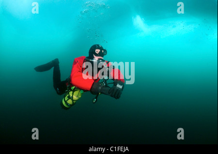 Scuba diver with sidemount under ice, in lake Baikal, Siberia, Russia, island Olkhon Stock Photo