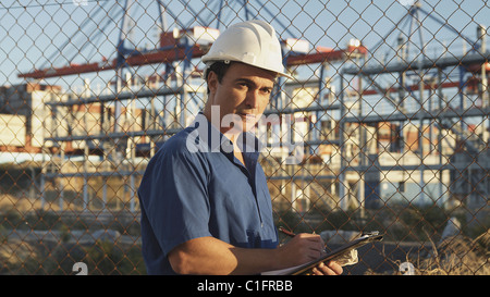 Hispanic man with clipboard on construction site Stock Photo