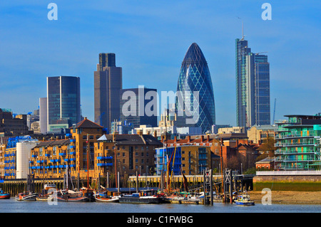 City of London skyline and Wapping seen from the Thames Path in Bermondsey, London, UK