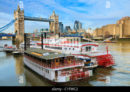Pleasure boats moored on the River Thames near Tower Bridge with the Financial District in the background, London, UK Stock Photo
