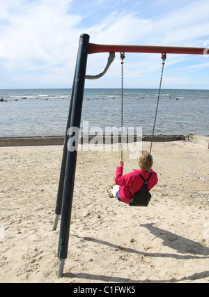 Woman on a swing on the beach, Visby, Gotland, Sweden. Stock Photo