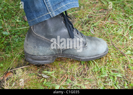 Black old worker shoe on green herb Stock Photo