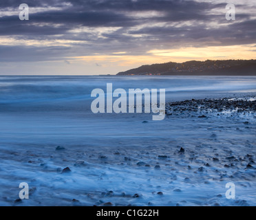 Ocean swept shores of Charmouth Beach at twilight, looking towards Lyme Regis, Jurassic Coast, Dorset, England. Stock Photo