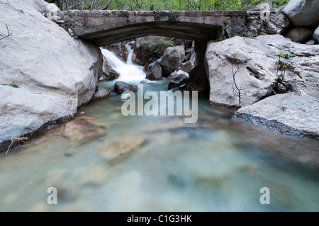 Fast creek runs through the rocky landscape and creates waterfalls. Stock Photo