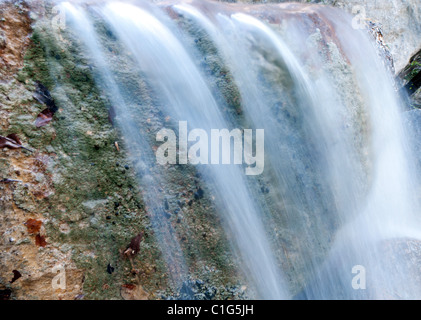 Fast creek runs through the rocky landscape and creates waterfalls. Stock Photo