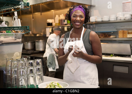 Black waitress working in restaurant kitchen Stock Photo