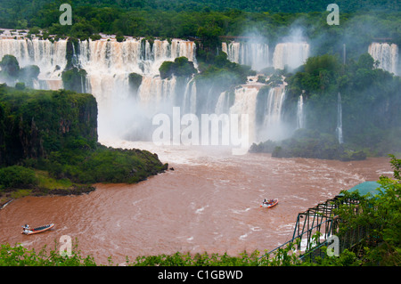 Tourists view Iguazu Falls, one of the world's most famous natural wonders, located at the border of Brazil and Argentina. Stock Photo