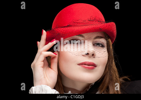 Model with black hat a veil with red face paint dark eyes. Uk