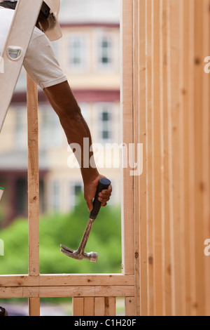 Hispanic carpenter hammering on a  house framing Stock Photo