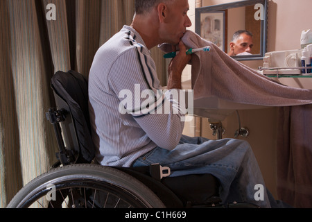 Man with spinal cord injury in a wheelchair brushing his teeth Stock Photo