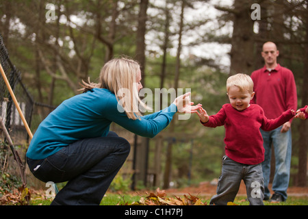 Woman signing the word 'Help' in American Sign Language while communicating with her son in a park Stock Photo