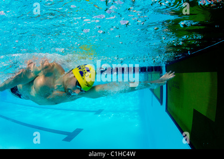 Male competitor in the collegiate Orange Bowl Swimming Classic finishes race. Stock Photo