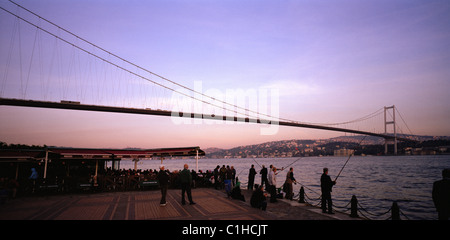 Men fishing in the Bosphorus under the First Bosphorus Bridge Bosphorus straits at Ortakoy in Istanbul in Turkey in Middle East Asia. Landscape Travel Stock Photo