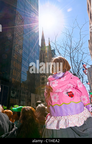 MARCH 17, 2011 - MANHATTAN: Sunflare, young girl in pink up on dad's shoulders watching 5th Avenue St Patrick's Day Parade Stock Photo