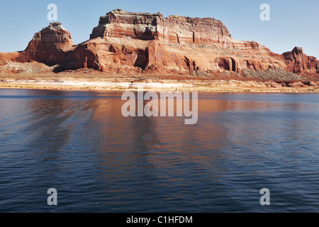 Picturesque red cliffs reflected in the smooth water of the lake Stock Photo