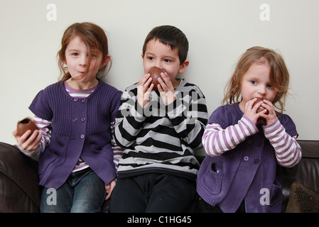 Children eating chocolate Easter Eggs, UK Stock Photo