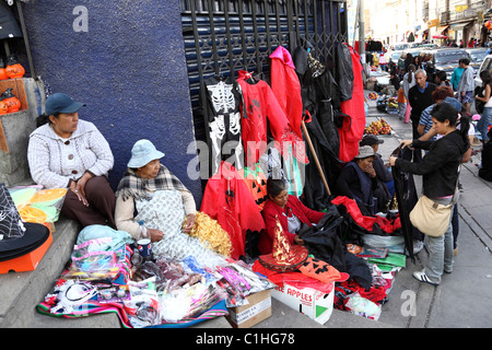Women selling costumes and masks in street market for Halloween, La Paz , Bolivia Stock Photo
