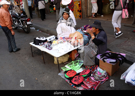 Aymara women selling rubber and plastic masks in street market for Halloween, La Paz , Bolivia Stock Photo